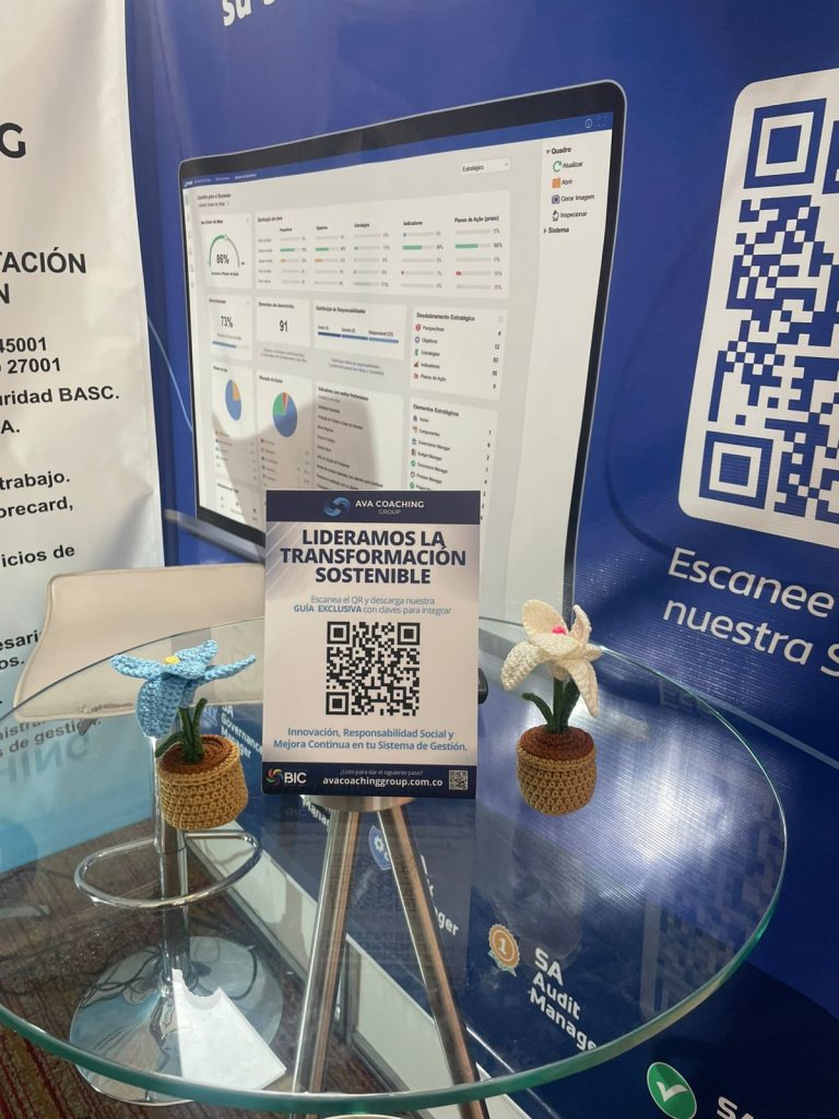 Detalle del stand de AVA COACHING GROUP en donde la mesa de atención se encuentra un hablador con un código QR pieza desarrollada por Simbiotic para ferias empresariales sostenibles